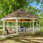 People sitting by the tables in a covered area